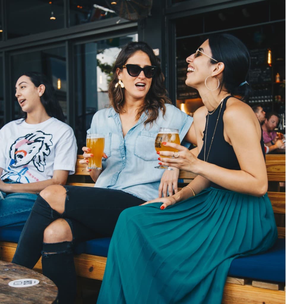 Friends laughing together over drinks at a restaurant