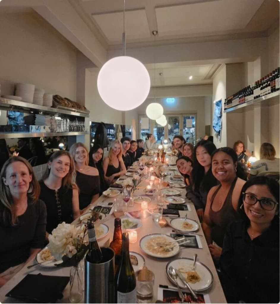 Large group enjoying a communal dinner at a long restaurant table