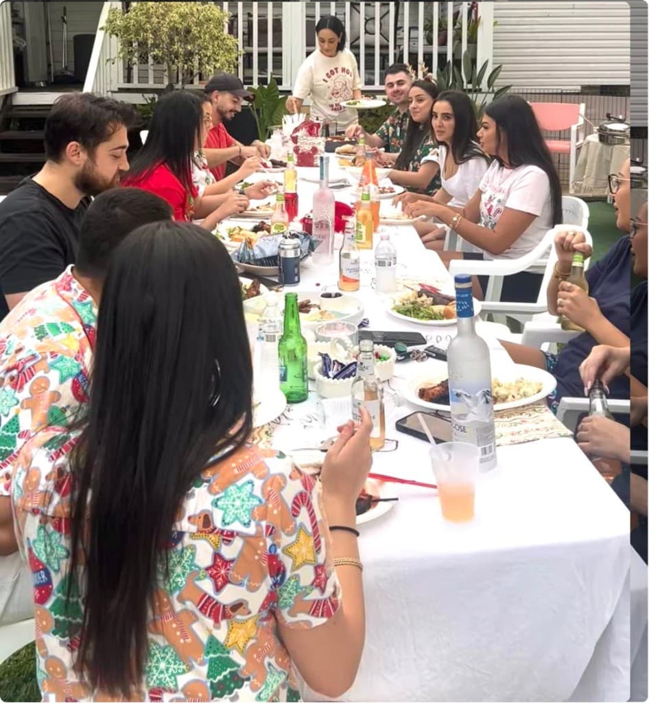 Friends sharing a festive outdoor meal together at a long table