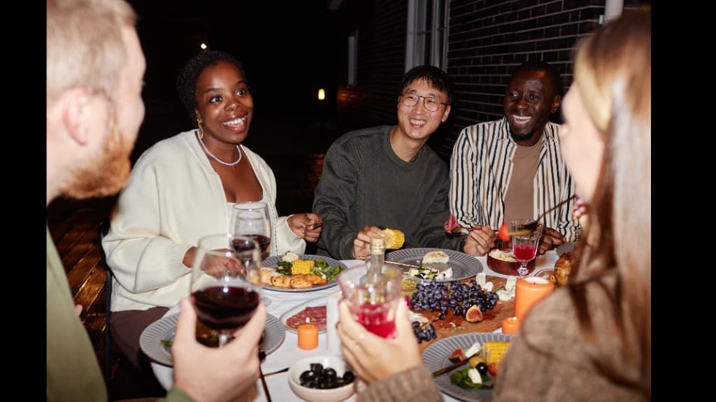 Friends sharing dinner together outdoors at night